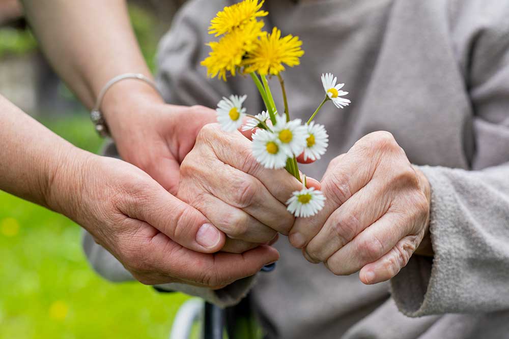 hospice care volunteer giving patient flowers